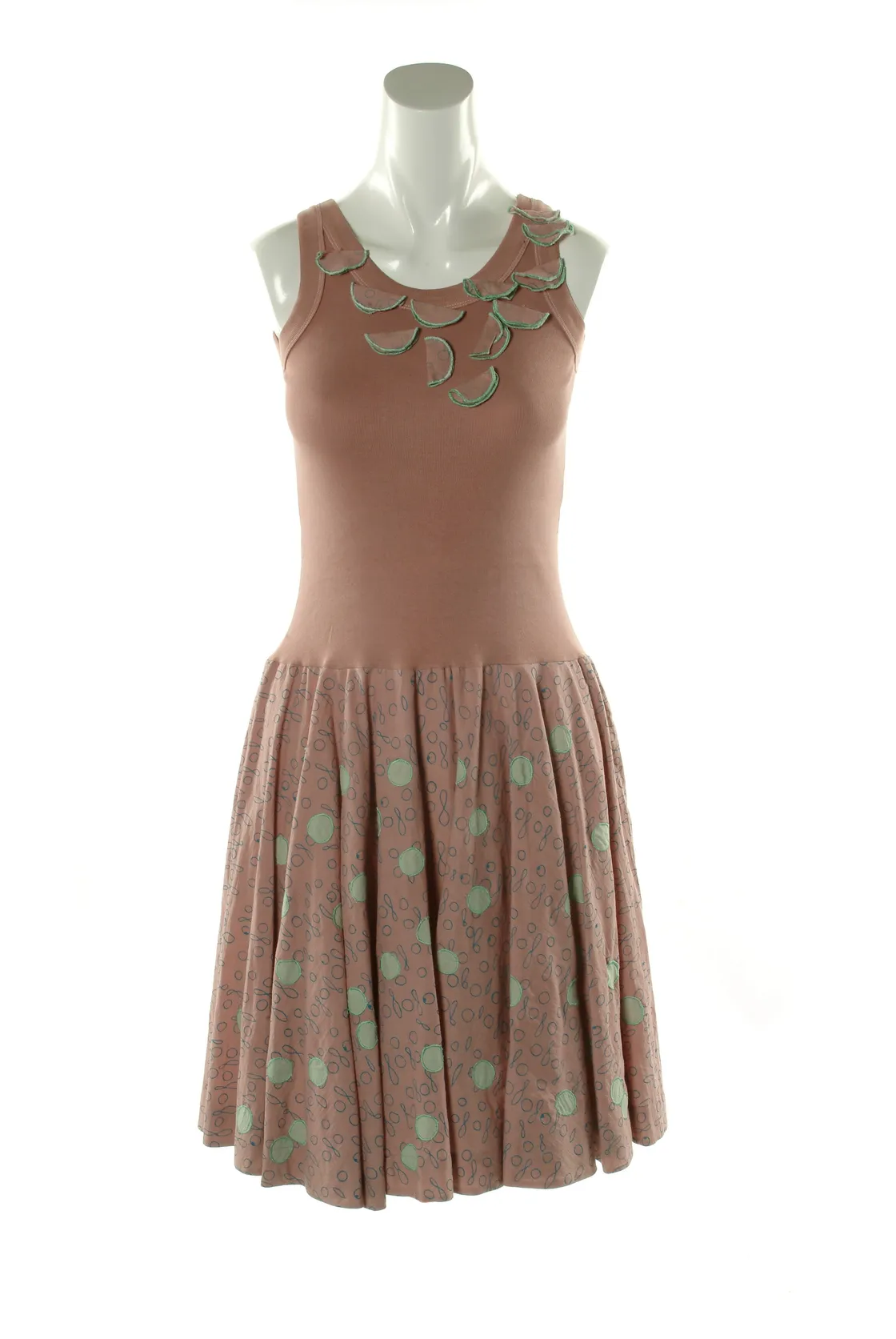 Mannequin displaying a sleeveless dress with floral accents on the neckline and a patterned skirt, isolated on a white background.