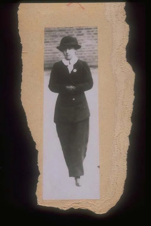 Vintage black-and-white photograph of a woman in early 20th-century attire walking, pasted on a textured, beige background.