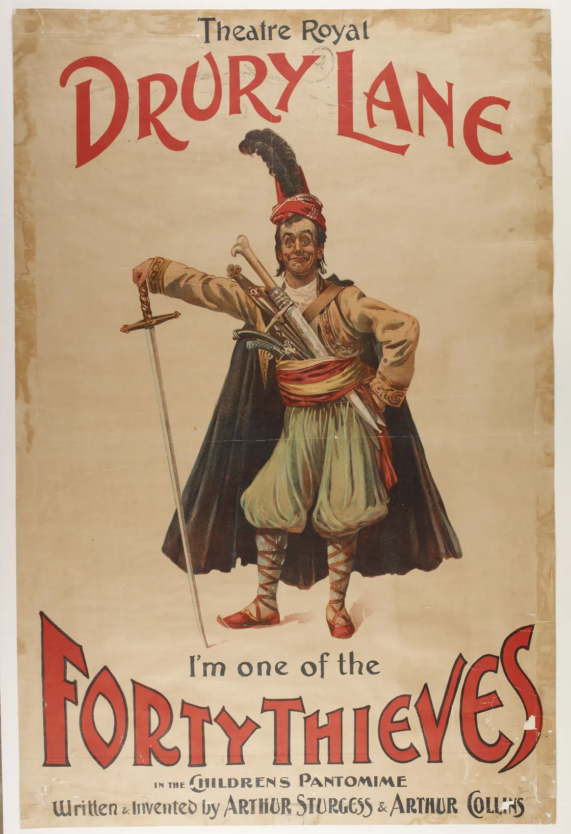 Vintage poster for "theatre royal drury lane" featuring an actor dressed as a character from "ali baba and the forty thieves," holding a sword.
