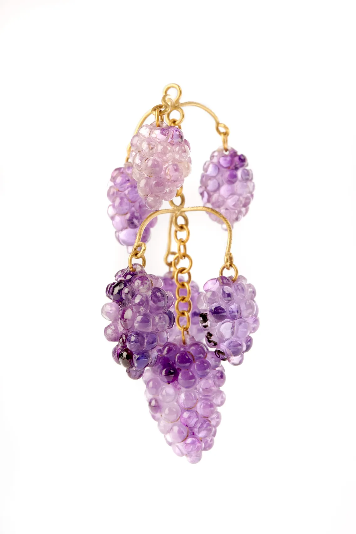 A pair of gold earrings featuring clusters of purple glass beads shaped like grapes, set against a white background.