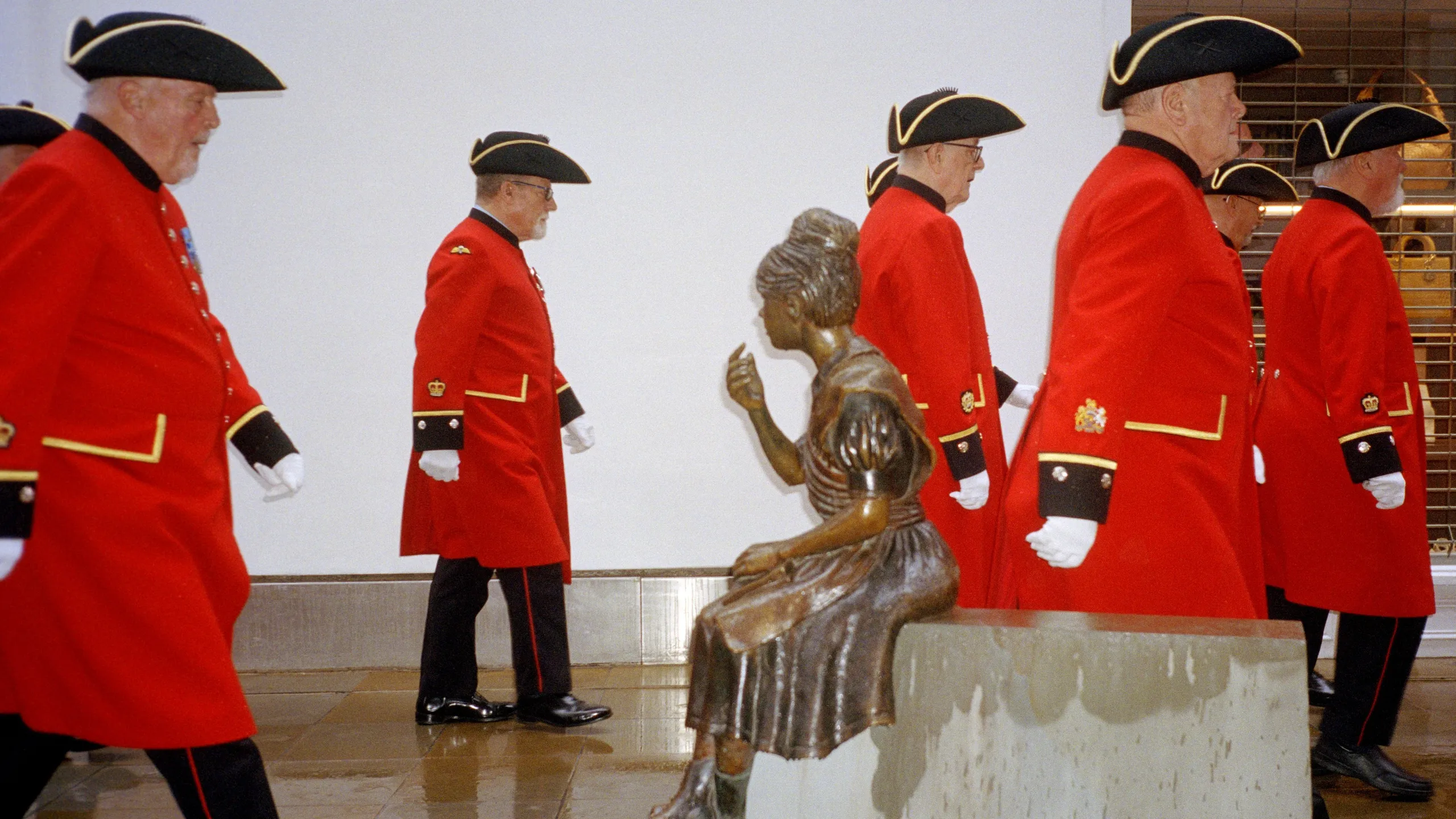 Digital photograph. Scanned from the negative. The King’s Coronation, Kings Road, Chelsea, UK. 
The Chelsea Pensioners march up Kings Road in formation, rain pouring, to serenade the King.