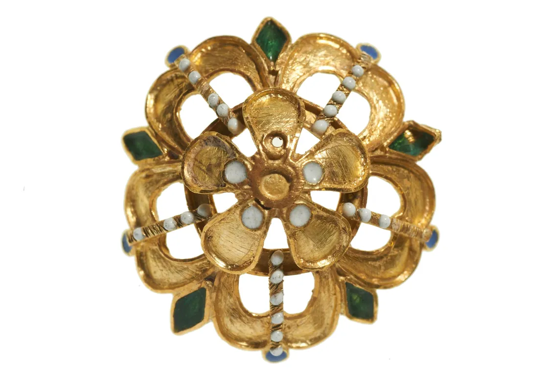 Gold brooch with a floral design, featuring green enamel petals and pearl accents, isolated on a white background.