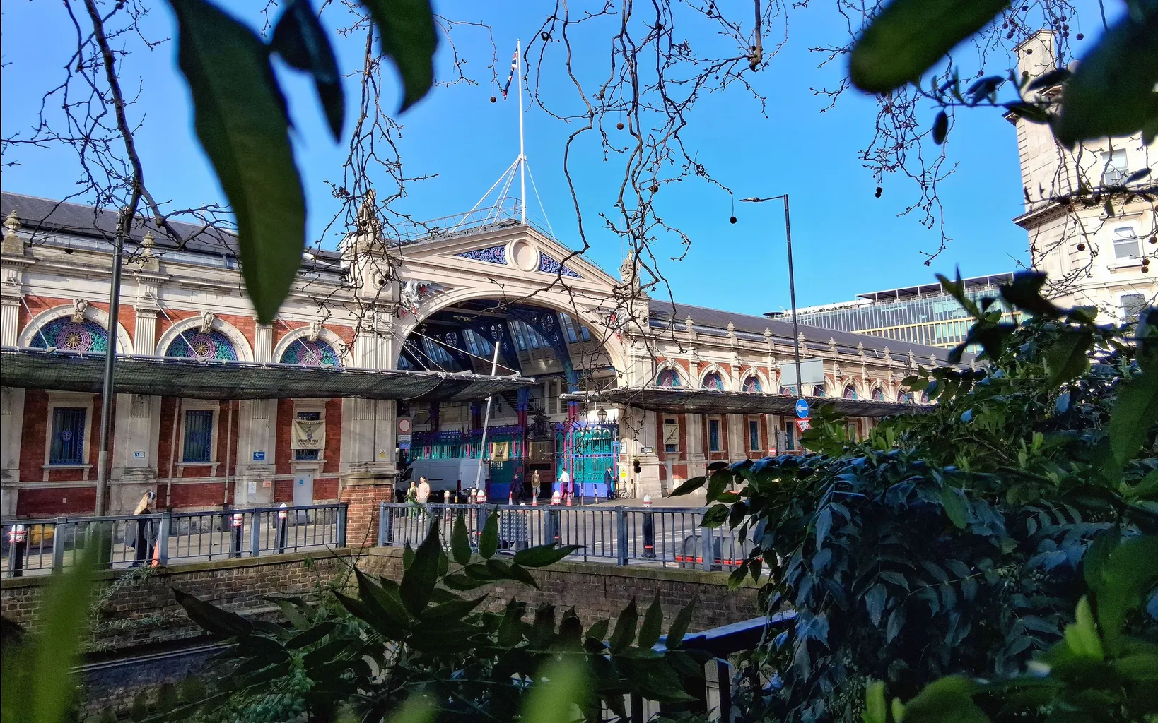 A wide-angle view of a Victorian market building with a blue sky seen above.