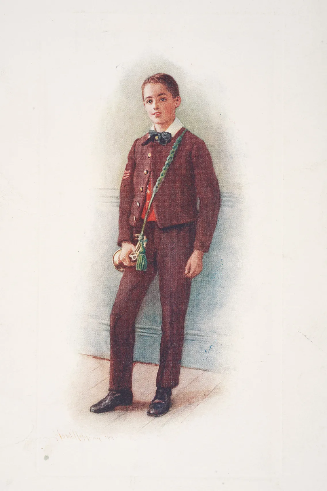 A young boy stands indoors wearing a brown suit, black shoes, and a green sash across his chest, holding a bugle in his right hand.