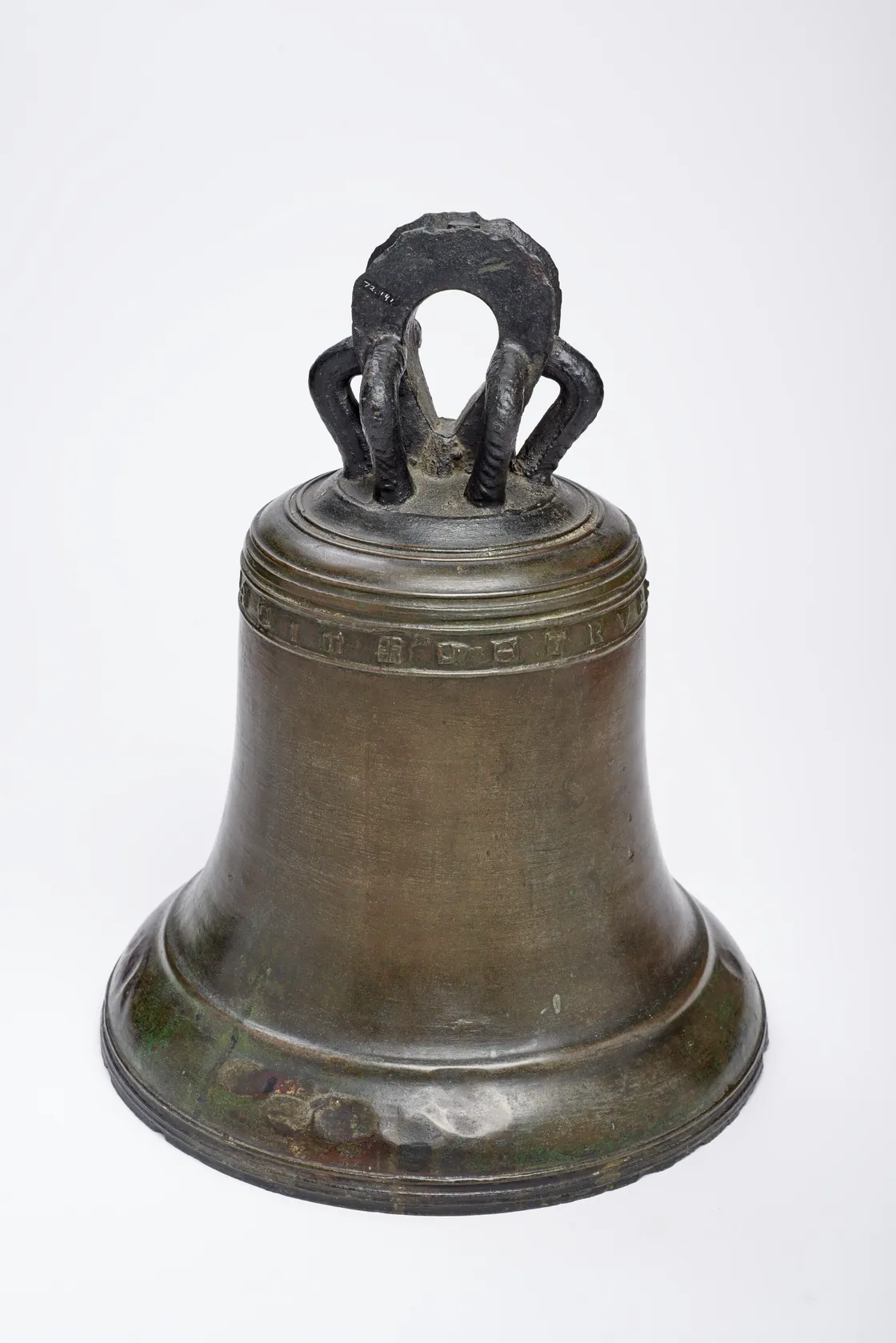 A large, bronze bell with a wide base and decorative top handle sits against a plain white background.