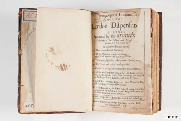 An open vintage book titled "The London Dispensatory," showing text with aged, slightly stained pages.