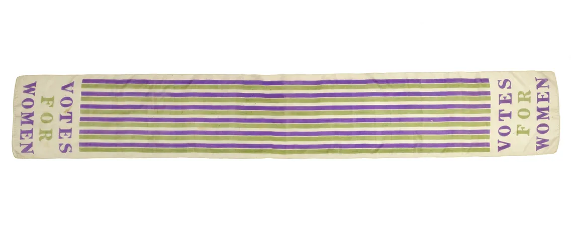 A historical white and purple striped sash with the words "votes for women" printed in bold letters, symbolizing the women's suffrage movement.