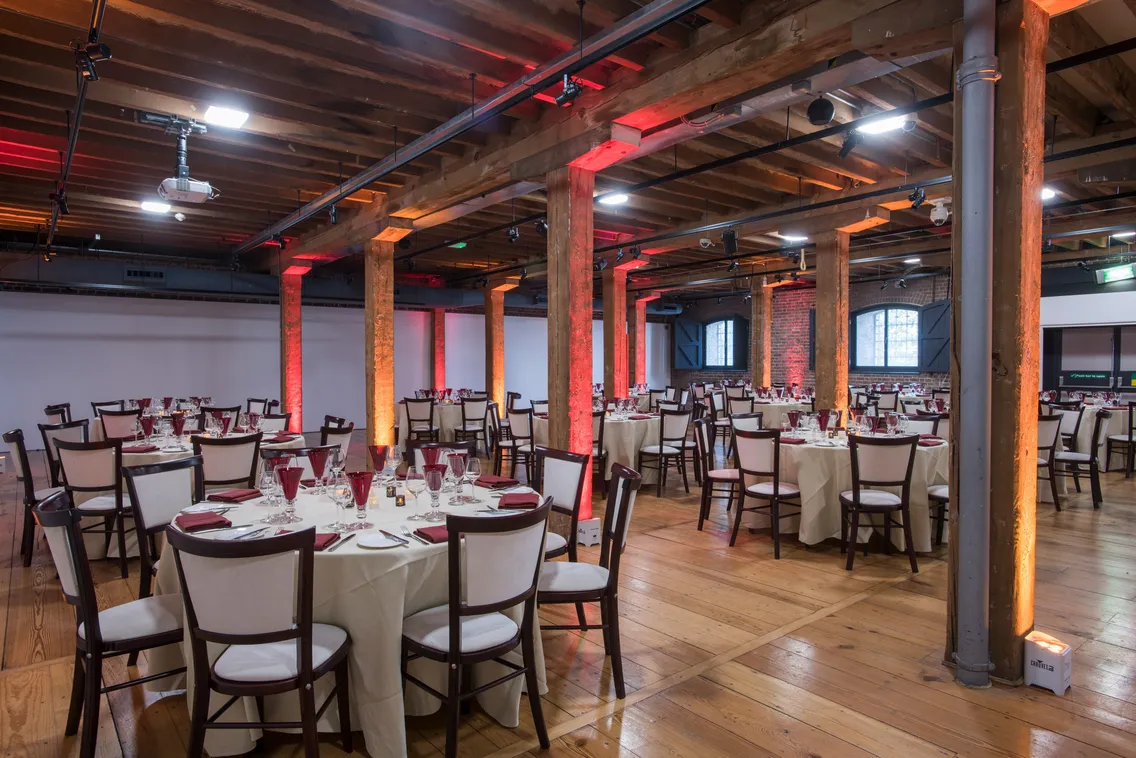 Spacious room with cabaret style seating and red lighting
