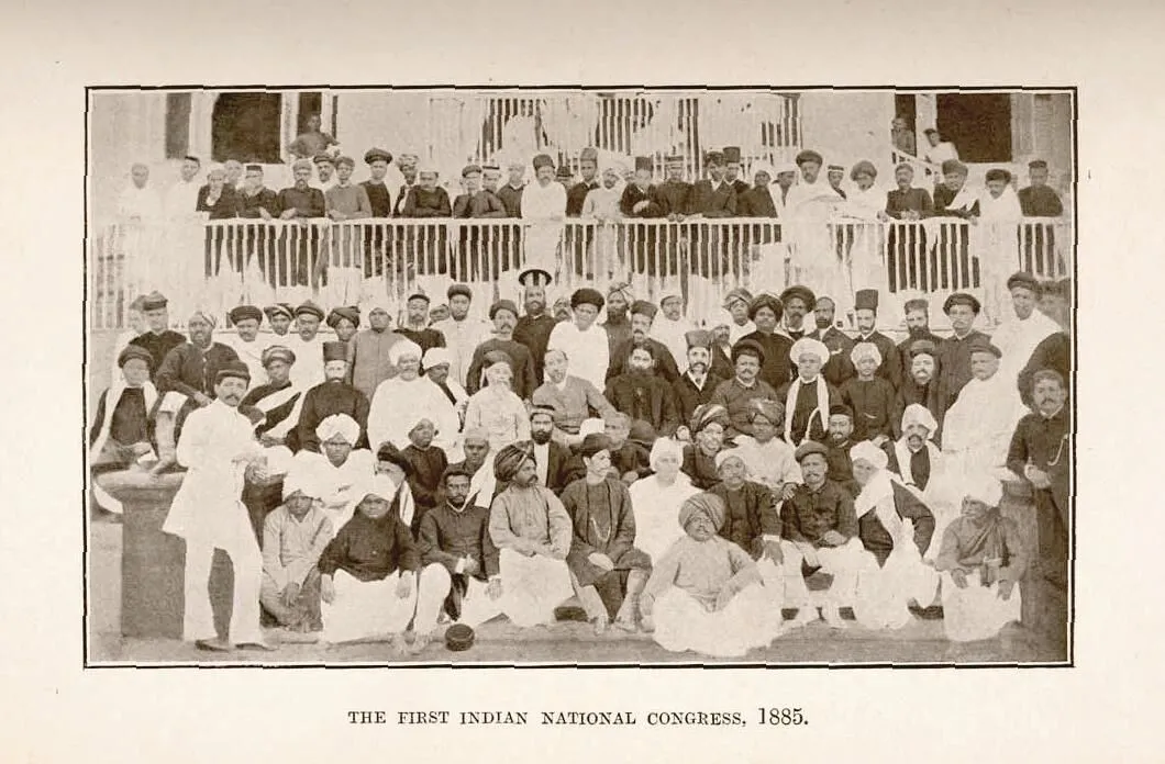 A large group of South Asian men posing and looking towards the camera