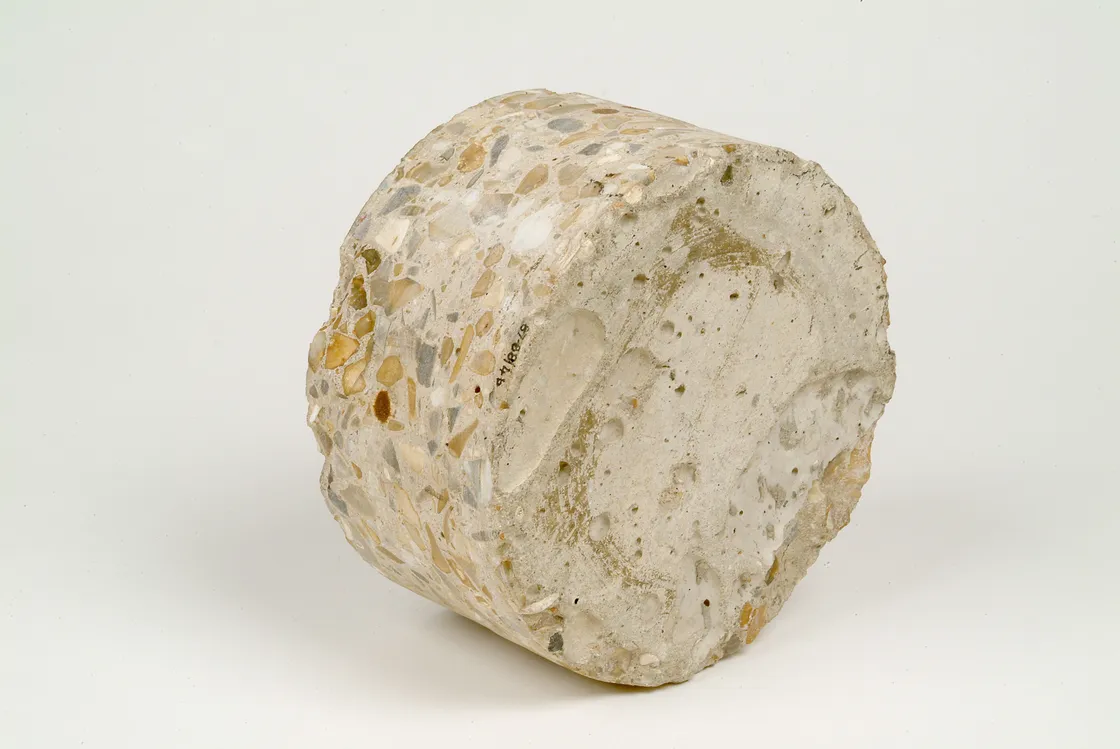 A photo of a speckled gray and white conglomerate rock with embedded pebbles and quartz fragments, isolated on a white background.