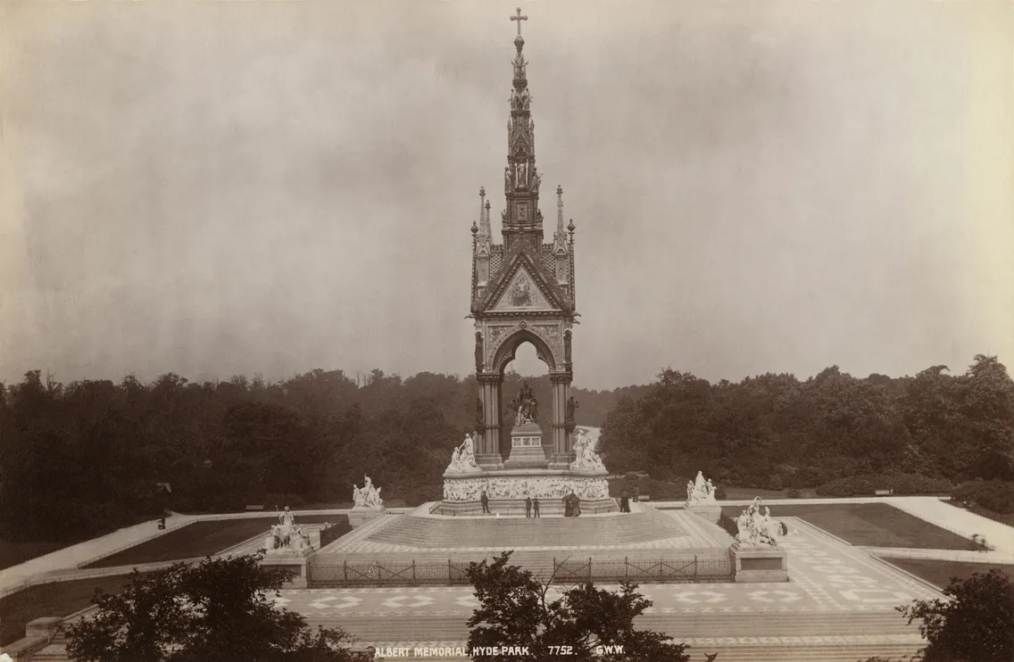 Historical black and white photo of the albert memorial in london, showcasing its ornate gothic architecture and statues under a cloudy sky.