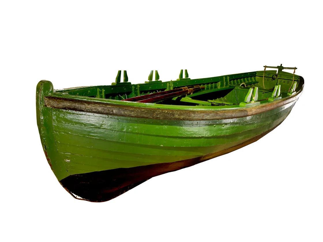 An old, green wooden rowboat isolated on a white background.