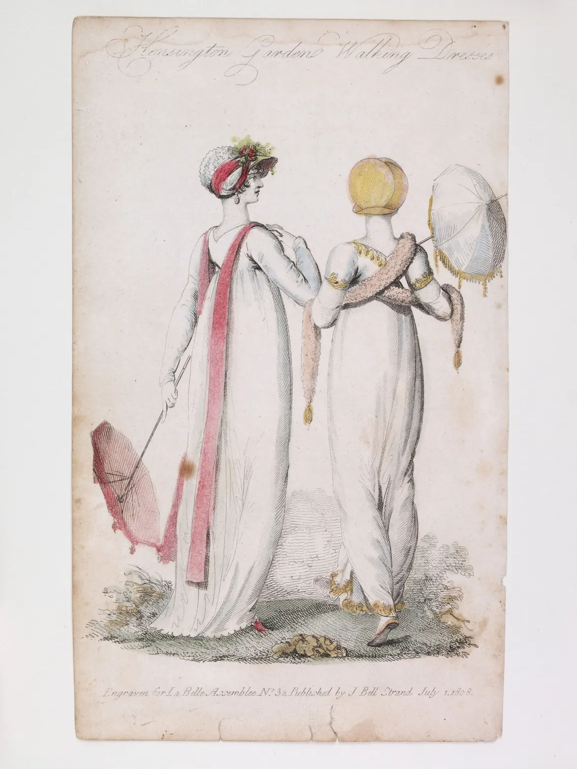 Antique fashion illustration depicting two women in classical greek-style dresses, one holding an umbrella and the other a parasol, both wearing decorative headpieces.