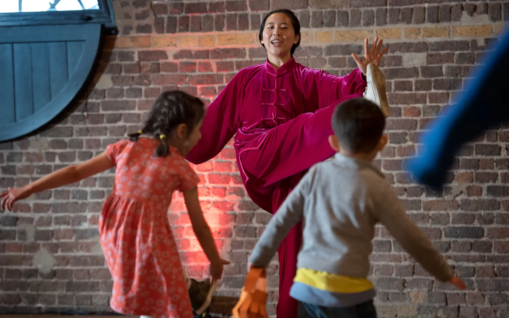 Adult and child focus on a craft project; the adult applies glue to a cardboard tube while the child observes. Both are wearing casual clothing and glasses.