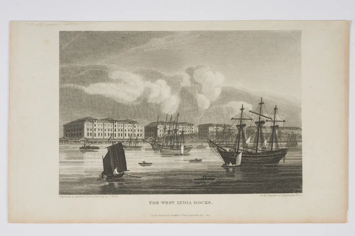 An engraving of the West India Docks with several sailboats and ships on the water, buildings in the background, and clouds in the sky, published by Laurie & Whittle, London, 1811.
