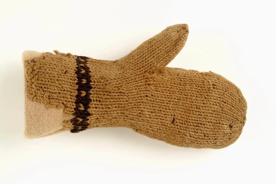 A knitted beige mitten with a dark brown stripe laid flat on a white background.