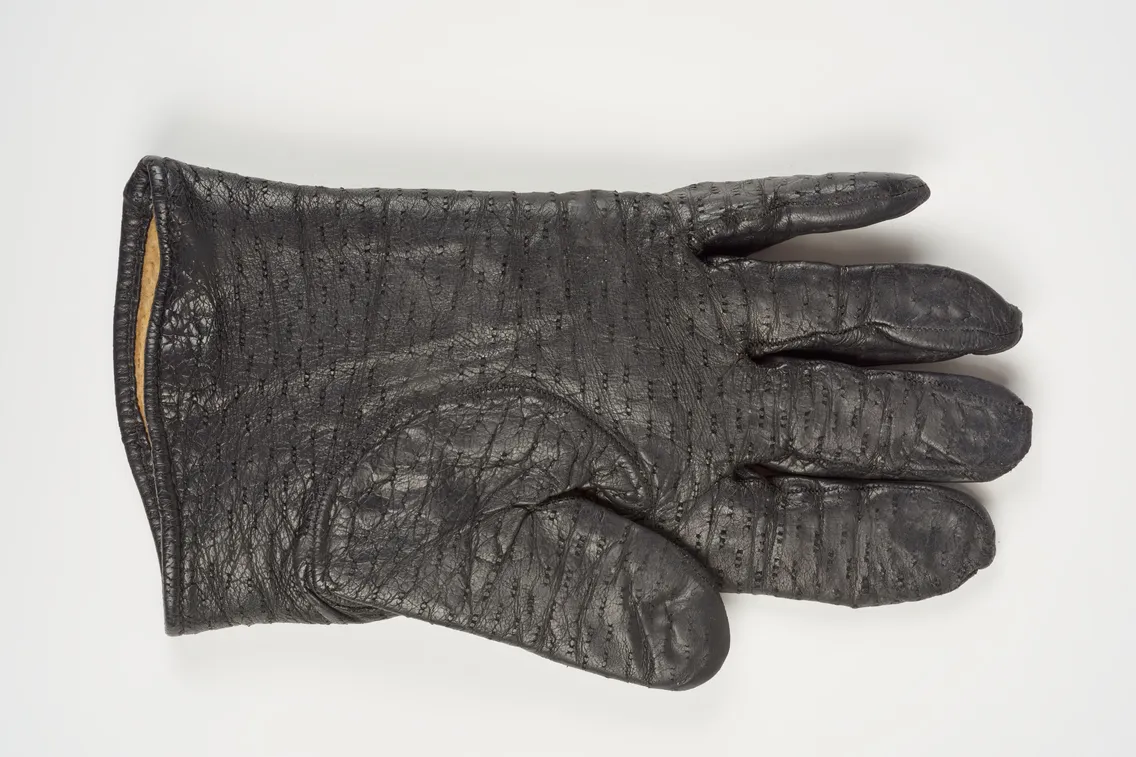 A single black leather glove is displayed flat on a white background, palm facing up.