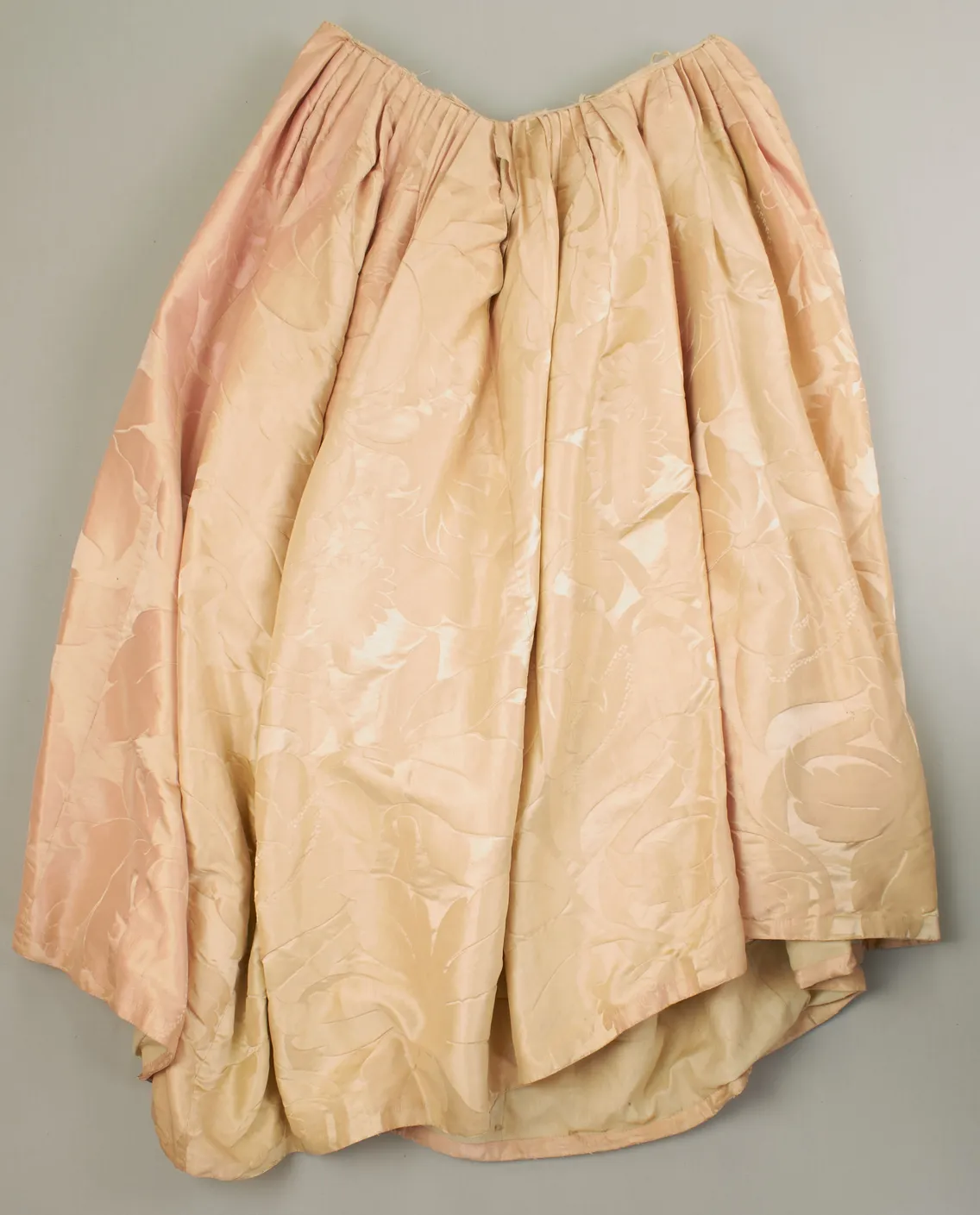 A vintage blush pink underskirt on a grey background